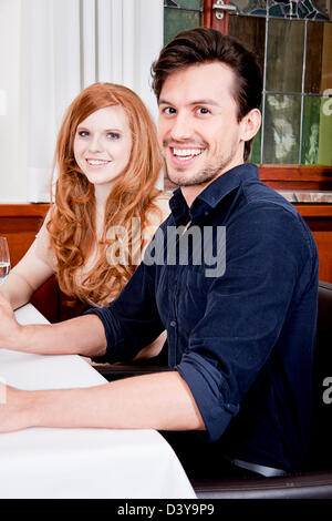 L'homme et de la femme dans le restaurant pour le dîner, boire du vin rouge et souriant Banque D'Images