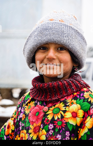 Portrait coloré de l'Ouzbek petite fille sur un jour de neige. Samarkand, Ouzbékistan Banque D'Images