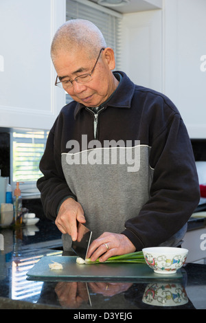 L'homme chinois hacher des oignons dans la cuisine Banque D'Images