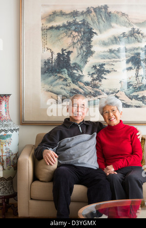 Chinese couple sitting on sofa Banque D'Images