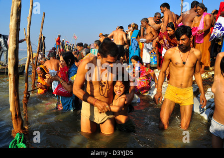 Père avec sa fille prendre une immersion sainte à la banque du Sangam confluence de fleuve Ganga, Yamnuna et mythique Saraswati . Banque D'Images