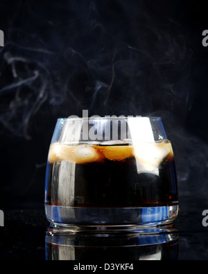 Le whiskey et le cola sur fond noir. Banque D'Images