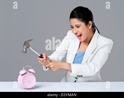 Businesswoman smashing réveil avec chien Banque D'Images