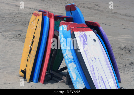 Body boards empilés ou planches de surf sur une plage de sable couverts sur la rive de l'océan Pacifique en Equateur, Tonsupa Banque D'Images