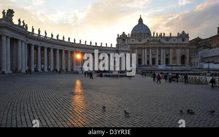 Les visiteurs de la Cité du Vatican à pied sur la Place Saint Pierre à Rome, Italie, 26 février 2013. Le soleil qui brille à travers les piliers. Photo : Bernd von Jutrczenka Banque D'Images