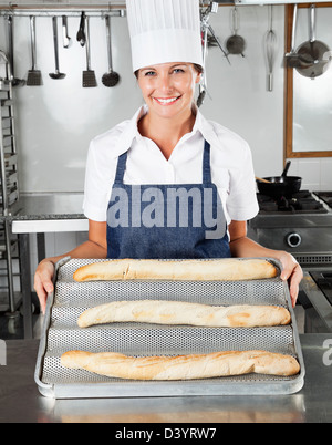 Femme Chef Presenting Loafs dans la cuisine Banque D'Images