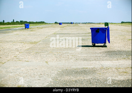 Grand bleu bacs roulants sur béton niveau au soleil Banque D'Images