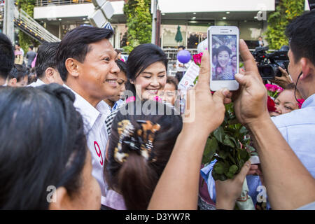 Bangkok, Thaïlande. 27 février 2013. Pol Gen PONGSAPAT PONGCHAREON (à gauche) et YINGLUCK Shinawatra, Premier Ministre de la Thaïlande, la campagne pour l'élection de Pongsapat gouverneur de Bangkok, alors qu'une personne avec un Yingluck photographies téléphone intelligent. Pongsapat Pongcharoen général de police (à la retraite), un ancien sous-chef de la police nationale qui a également servi en tant que secrétaire général de l'organe de contrôle des stupéfiants est le candidat du Parti Pheu Thai dans la prochaine élection du gouverneur de Bangkok. (Il a démissionné de la police pour s'exécuter pour gouverneur. Credit : ZUMA Press, Inc. / Alamy Live News Banque D'Images