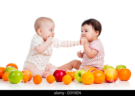 Bébés Enfants drôles avec des aliments sains fruits isolé sur fond blanc Banque D'Images