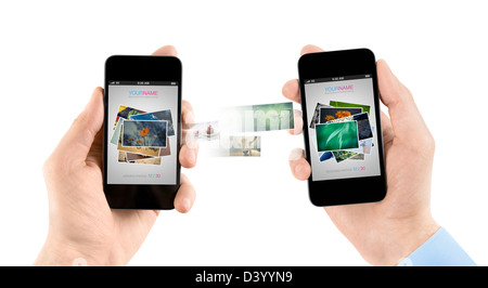 Deux mains tenant les smartphones mobiles lors du transfert de photos de l'un à l'autre. Banque D'Images