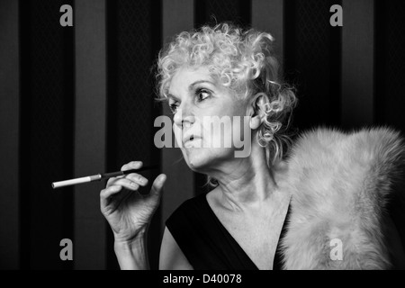 Bond senior woman holding un porte-cigarette Banque D'Images