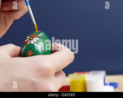 Peinture de main de femme œuf de pâques avec paintbrush Banque D'Images