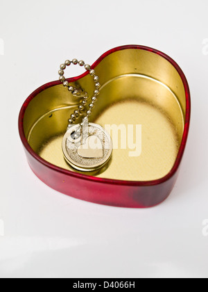 Un coeur miniature key-chain dans un cœur rouge en acier inoxydable, un symbole universel de l'amour Banque D'Images