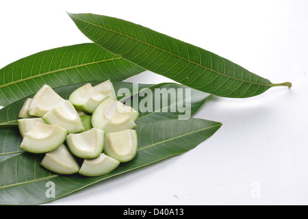 Coupe brute mango mangue fraîche sur les feuilles des arbres. Banque D'Images