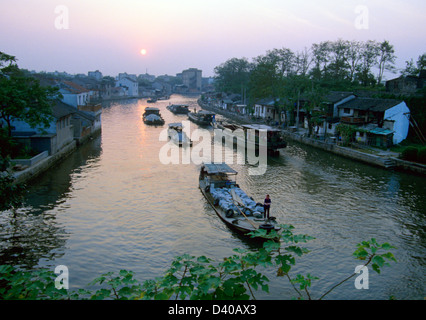 Les chalands chargés de produits industriels flotter vers le bas sur le Grand Canal de Suzhou, Chine au lever du soleil Banque D'Images