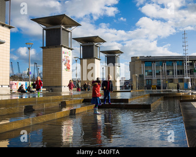 Enfants jouant dans les fontaines de la Place du Millénaire, Bristol, Angleterre. Banque D'Images