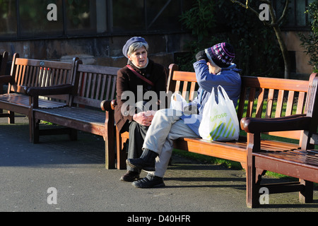 Deux femmes font une pause shopping à siéger à parler dans un parc local, Glasgow, Écosse, Royaume-Uni Banque D'Images