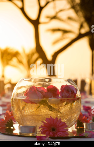 Centre de table romantique avec bol et fleurs dans le soleil du soir à l'extérieur. Banque D'Images