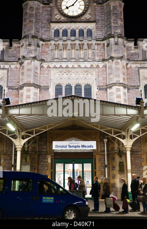 Les gens font la queue pour un taxi à la gare de Bristol Temple Meads de nuit avec l'impressionnant face à la gare de courts. Banque D'Images