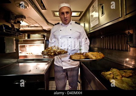 Chef servant du poisson et des frites sur sous-marin nucléaire HMS Talent Banque D'Images