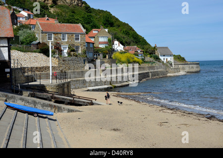 Woman walking dog sur runswick bay beach Banque D'Images