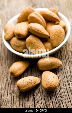 Amandes en coques sur table en bois Banque D'Images