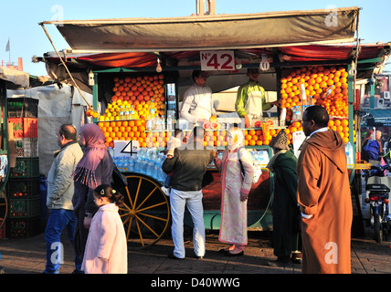 Les gens en face d'un vendeur de jus d'orange à la place Jemaa El Fna, Marrakech (Marrakech, Maroc) Banque D'Images