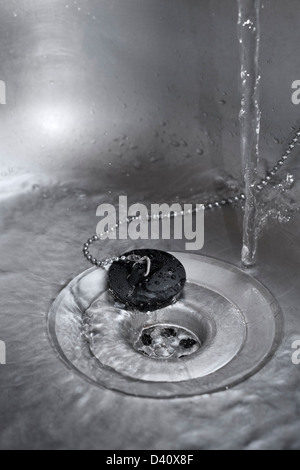 Évier de cuisine - l'eau de couler le plughole dans un évier de cuisine Banque D'Images