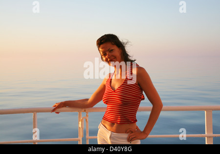 Heureux dame sur la chemise en croisière coucher du soleil Banque D'Images