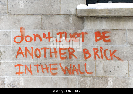 'Ne pas être juste une autre brique dans le mur' graffiti sur un mur de briques. Banque D'Images