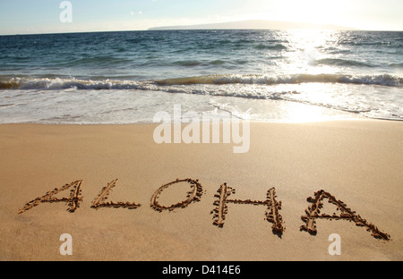 Le mot Aloha écrit dans une plage de sable Banque D'Images