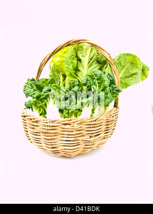 Des petits bok choy et cos salade en rotin panier isolé sur fond blanc Banque D'Images