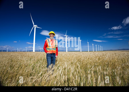 Technicien en énergie éolienne debout à côté d'éolienne, Pincher Creek, Alberta, Canada. Banque D'Images