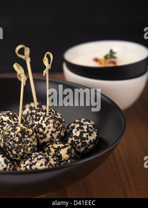 Boules de fromage de chèvre épicé roulé dans des graines de sésame. Banque D'Images