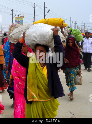 Les dévots Hindous portent leurs effets sur leurs têtes qu'il quitte le Kumbh Mela à Allahabad Banque D'Images