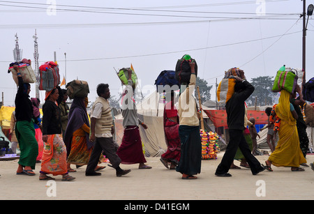 Les dévots Hindous portent leurs effets sur leurs têtes qu'il quitte le Kumbh Mela à Allahabad Banque D'Images