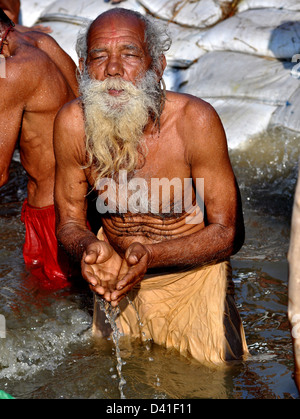 Un hindou dévots prie que se baigner dans le Sangam ou confluent de la Yamuna, le Gange et le fleuve mythique Saraswati Banque D'Images