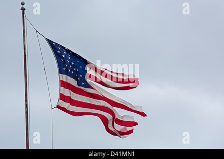 Detroit, Michigan - un drapeau en lambeaux en vol au dessus d'une activité commerciale sur la partie est de Detroit. Banque D'Images