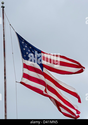 Detroit, Michigan - un drapeau en lambeaux en vol au dessus d'une activité commerciale sur la partie est de Detroit. Banque D'Images