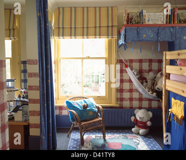 Jaune à rayures aveugles sur Fenêtre avec cadre jaune dans les chambres d'enfants avec lits superposés et rouge sur le mur peint des carrés vérifier Banque D'Images
