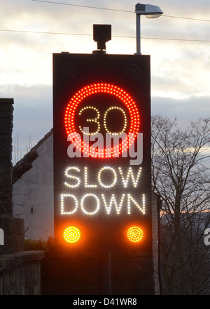 Ralentir roadsign alerte déclenchée par les véhicules en approche au crépuscule, l'elmsall, Yorkshire, Royaume-Uni Banque D'Images