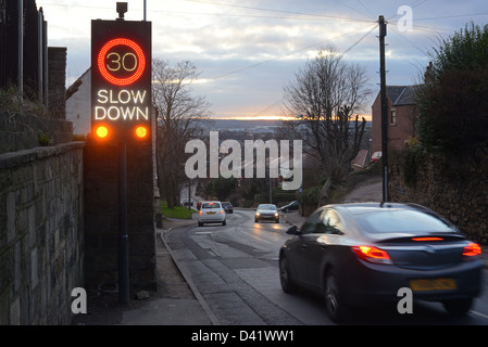 Ralentir roadsign alerte déclenchée par les véhicules en approche au crépuscule, l'elmsall, Yorkshire, Royaume-Uni Banque D'Images