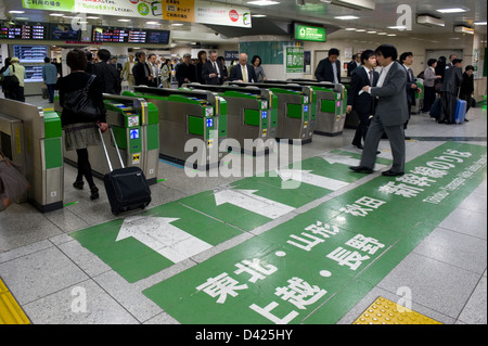 Les hommes d'affaires et les voyageurs de passage aux guichets électroniques sur leur façon de plates-formes de shinkansen, le train à la gare de Tokyo Banque D'Images