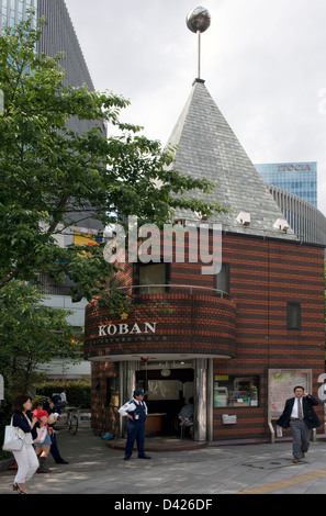 Agent de police aux portes d'une poste de quartier appelé un 'koban' (police fort) sur un coin à Ginza, Tokyo Banque D'Images