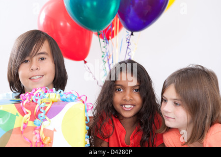 Multi-culturel trois enfants à une fête d'anniversaire Banque D'Images