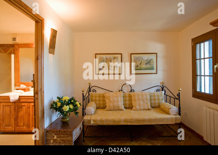 Vérifier jaune coussins sur metal canapé dans la petite aire de séjour en appartement espagnol Banque D'Images