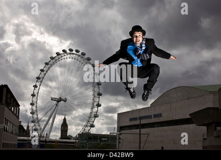 Parkour runner en combinaison complète de sauter devant le London eye Banque D'Images