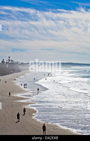 Silhouettes de personnes à pied et de surfeurs sur la plage et l'eau en Californie Banque D'Images