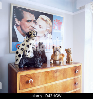 Affiche encadrée de la cinquantaine de Cary Grant et Grace Kelly sur le mur au-dessus de la collection grand chien chine ornements sur une commode Banque D'Images