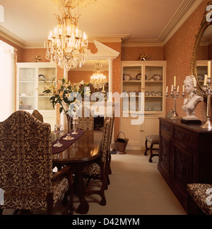 Tapisserie Chandelier de chaises rembourrées et table en acajou au townhouse salle à manger avec placards papier peint damassé Banque D'Images